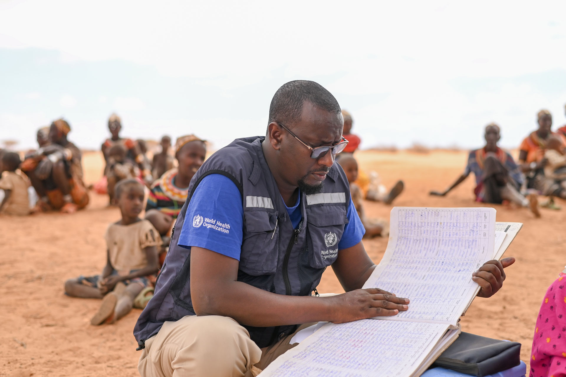 <p><sub>On 20 September 2022, WHO's Dr Adam Haji looks at medical records during a health screening by a mobile team in Korr, Marsabit. </sub></p> <p><sub>On 20 September 2022, WHO's Dr Adam Haji looks at medical records during a health screening by a mobile team in Korr, Marsabit. </sub></p>